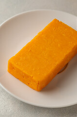 Cheddar orange cheese block, Graysons background, copy space.