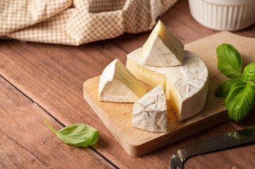 Brie, soft cheese slices on cutting board. Copy space