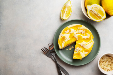 Lemon cheesecake tart or pie, with fresh lemons, top view with copy space.  - obrazy, fototapety, plakaty
