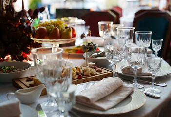 table setting for a festive dinner. empty wine glasses, tableware and snacks.