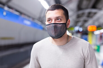 Portrait of male passenger in protective mask on underground platform