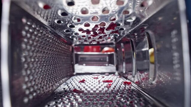 Slow motion close-up video of a chef grating beets with a grater. The process of cooking and cutting vegetables in the kitchen. High quality 4k footage