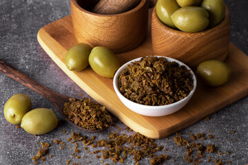Dried green olives in wooden bowl. Pickled olives.