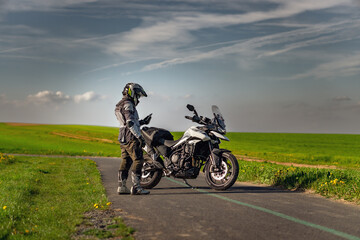 Fototapeta na wymiar Landscape with motorcycle rider on the road near triumph motorcycle