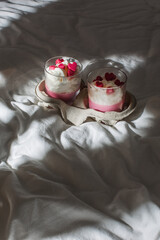 Strawberry dessert in a cup on a white background. Red chocolate hearts. Breakfast in bed.
