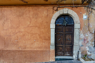 Old destroyed closed door in an orange destroyed wall