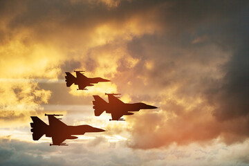 Air Force Day. Aircraft silhouettes on background of sunset. Combat flight of interceptors on a...