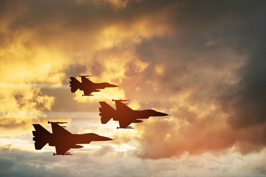 Air Force Day. Aircraft silhouettes on background of sunset. Combat flight of interceptors on a mission.