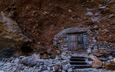 Fototapeta premium An old door closing a hidden entrance to the inside of the rock