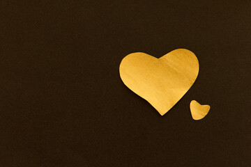 Golden sparkling heart on a black background, made of paper, romantic and festive symbol, background