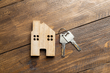 house and key on a wooden surface top view / apartment rental