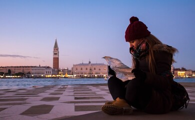 Young girl reading a map with San Marco Square in Venice in the background