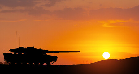 Fototapeta premium Silhouette of army tank at sunset sky background. Military machinery.