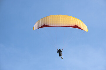 Paragliding is extreme action sport. Person is paragliding. Selective focus. Open space area. 