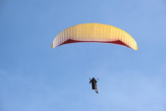 Paragliding is extreme action sport. Person is paragliding. Selective focus. Open space area. 
