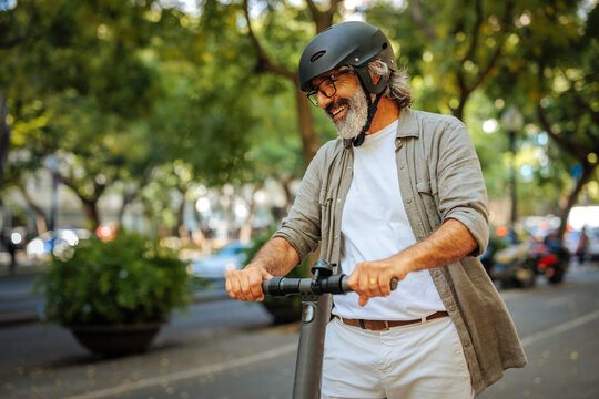 Cheerful mature man on electric scooter.