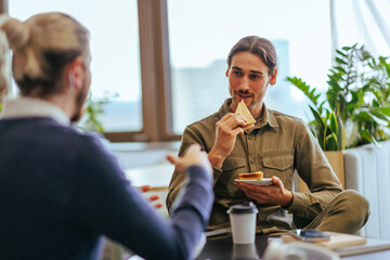 Coworkers having casual breakfast at work.
