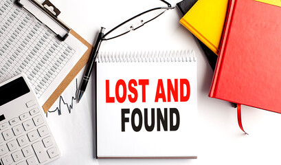 LOST AND FOUND text on notebook with clipboard and calculator on white background