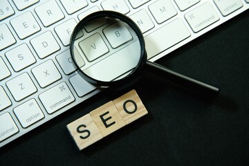 Magnifying glass and laptop keyboard. Seo.