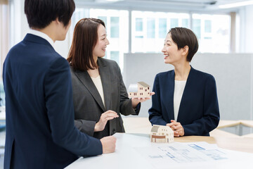 不動産の模型を使って打ち合わせをする人々