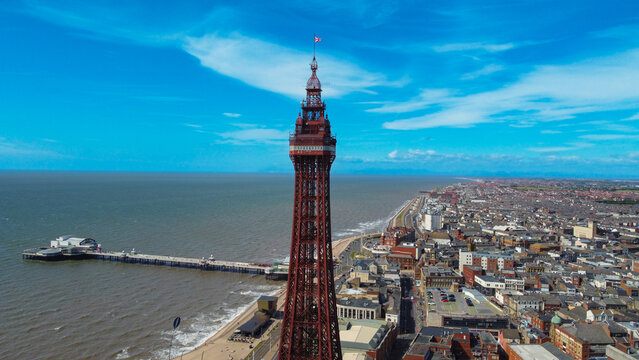 pier overhead view. Birds flying on the Ferris wheel and the pier. Waves crashing on the shore in the blue sea