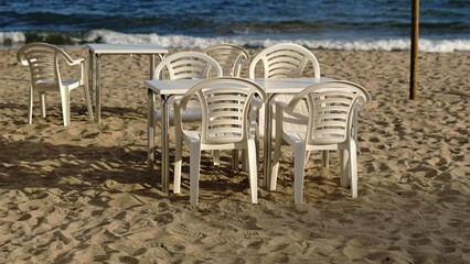 empty chairs and tables on the beach