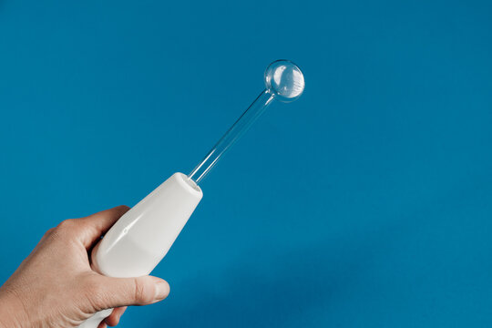 Woman with darsonval on turquoise background, closeup. Space for text