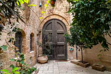 A wooden arched doorway and door in the historic medieval and ancient old port city of Jaffa, Israel.