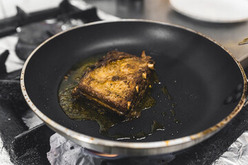 Roasting pork ribs with gravy on frying pan. Polish cuisine. Restaurant kitchen food preparation process. Horizontal indoor shot. High quality photo