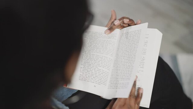 Indian woman reads interesting history book flipping pages on blurred background. Female student gets prepared for coursework at college closeup