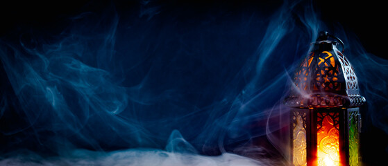 Ramadan Kareem banner design with lantern on dark blue background with smoke. Eid Mubarak, Muslim Holy Month header template. © photoguns