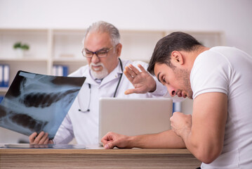 Obraz premium Young male patient visiting old male doctor radiologist