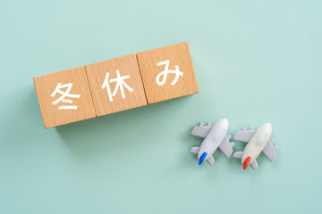 冬休みと書かれたブロックと飛行機