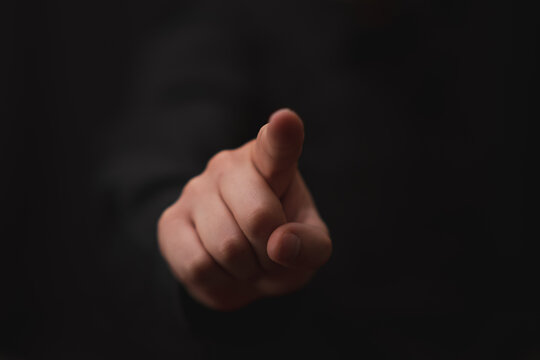 Hand pointing to screen button on black background