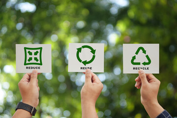 Hand holding reduce, reuse, recycle symbol on green bokeh background. Ecological and save the earth...