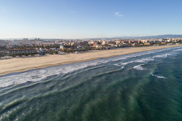 Aerial view of the beach of valencia and the coastline, late afternoon with waves, Spain