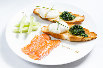 Breakfast with poached egg, bruschetta, salmon, cucumber, spinach.
