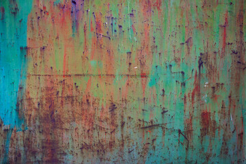 multicolored rusty and weathered metal surface,with shades of turquoise blue, orange, green, red and yellow colors - texture of a fence for the background of a steampunk wallpaper
