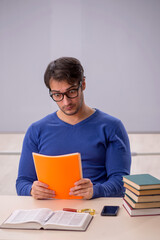 Young male student preparing for exams in the classroom