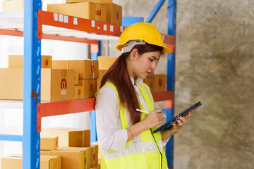 Attractive asia woman warehouse stock checking product stock on shelf.