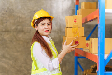 Attractive asia woman warehouse stock checking product stock on shelf.