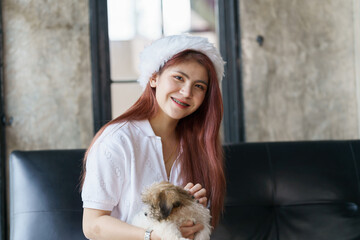 Asian woman relax on sofa in holiday with her dog, pet lover.