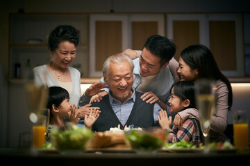 three generation asian family celebrating grandpa's birthday at home - Powered by Adobe