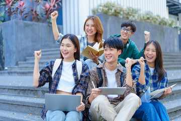 Attractive asian college student using laptop and tablet studying with group of friends together with english language classroom, social media and education concept.