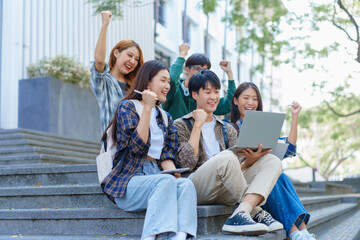 Attractive asian college student using laptop and tablet studying with group of friends together with english language classroom, social media and education concept.