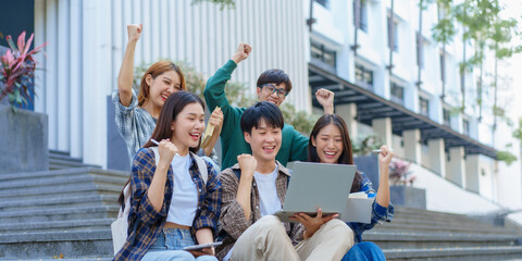 Fototapeta premium Attractive asian college student using laptop and tablet studying with group of friends together with english language classroom, social media and education concept.