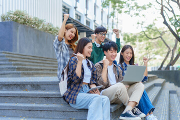 Attractive asian college student using laptop and tablet studying with group of friends together with english language classroom, social media and education concept.