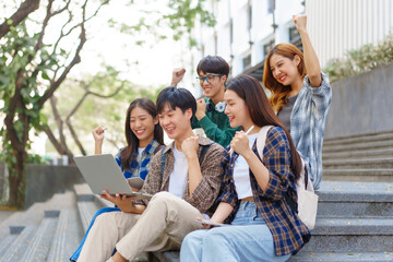 Attractive asian college student using laptop and tablet studying with group of friends together with english language classroom, social media and education concept.