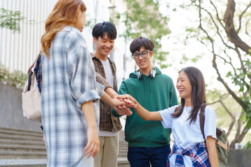 Attractive asian college student using laptop and tablet studying with group of friends together with english language classroom, social media and education concept.