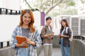 Attractive asian college student using laptop and tablet studying with group of friends together with english language classroom, social media and education concept.